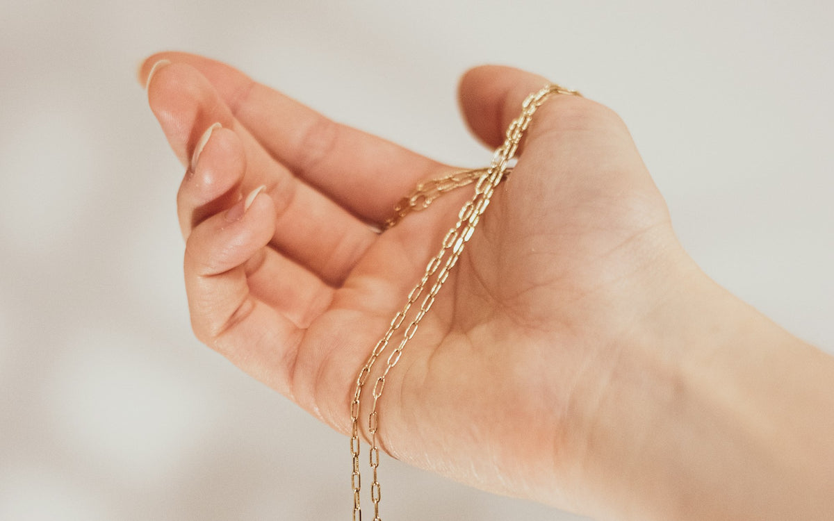 Heart charm necklace held in the hand