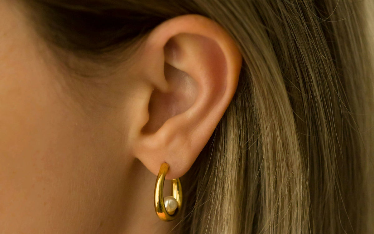 Hoop huggie earring worn on the ear