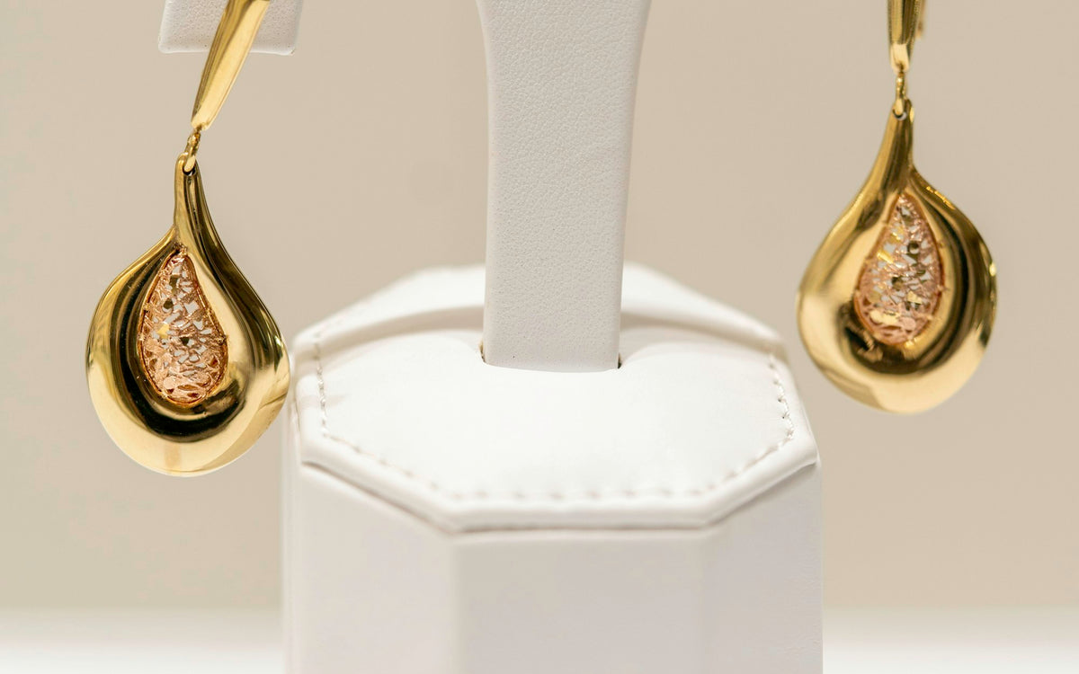 Gold and lab-grown diamond earrings on a stand