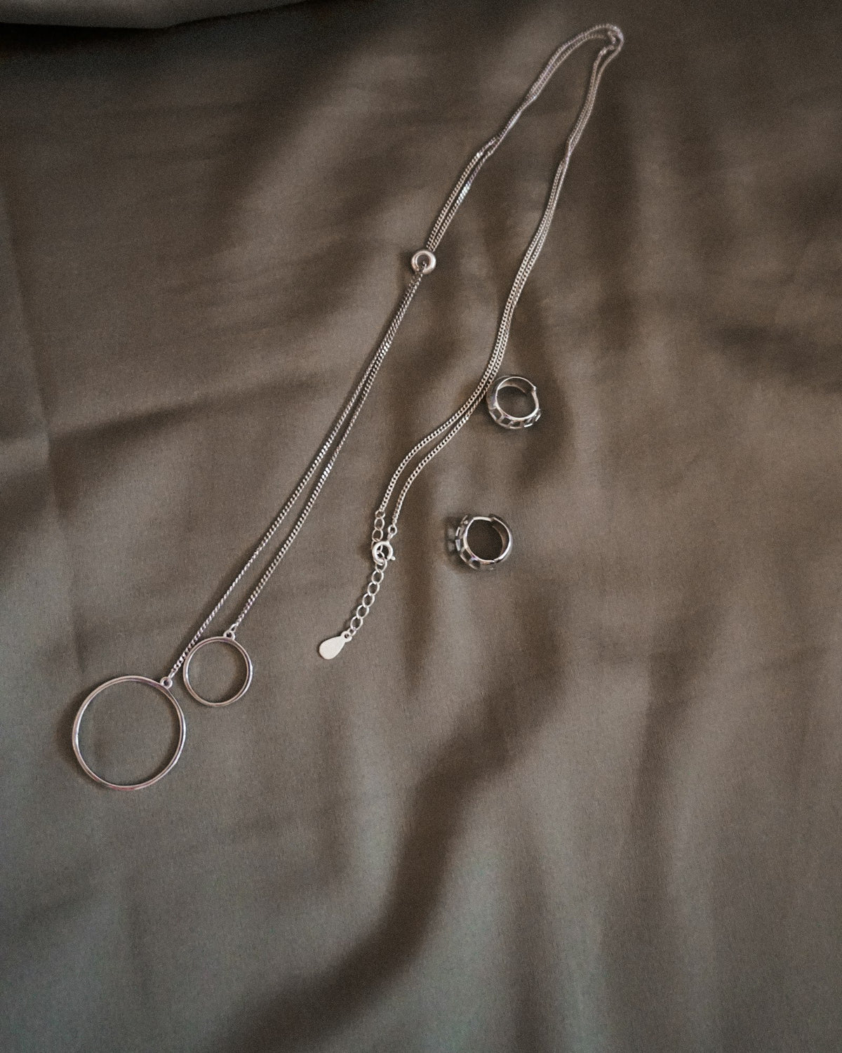 Silver necklace on white textile