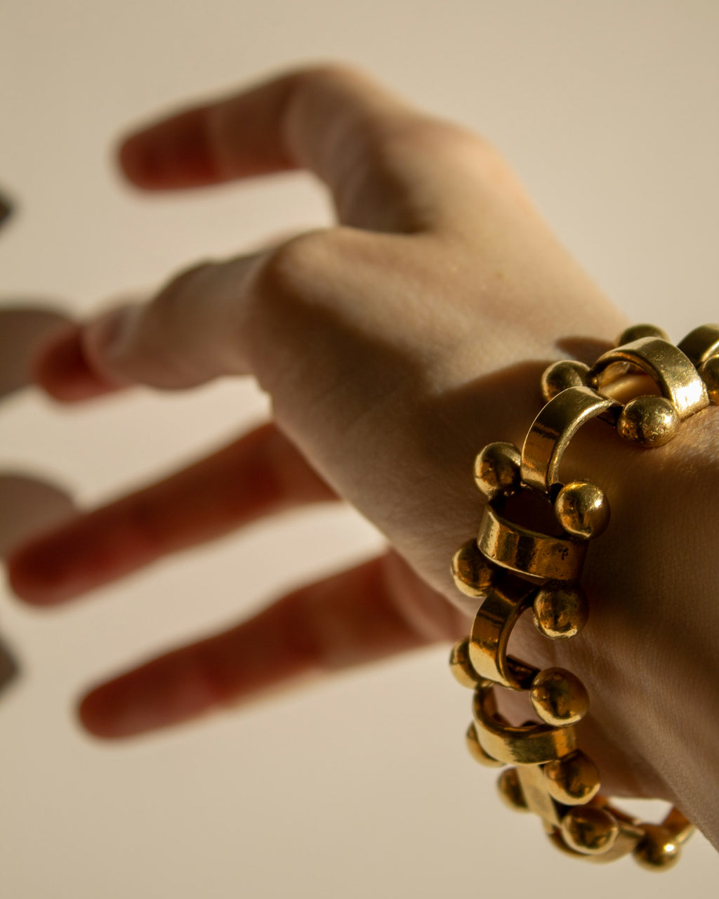 Gold curb chain bracelet worn on the wrist
