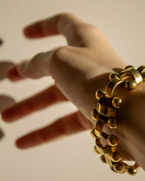 Gold curb chain bracelet worn on the wrist