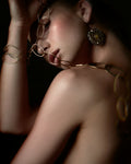 Woman wearing gold statement drop earrings