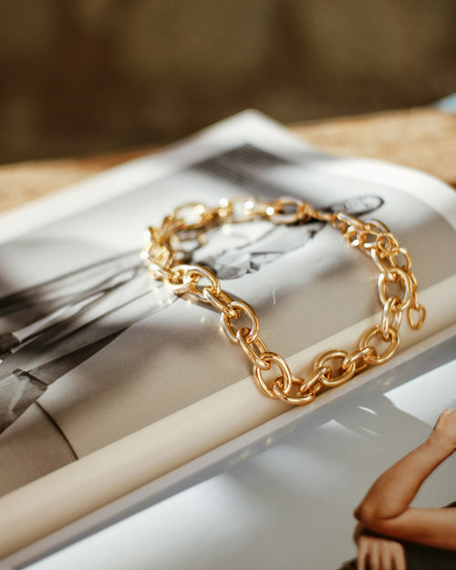 Gold chain bracelet on a magazine