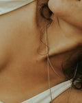 Fine chain draped at the collarbone