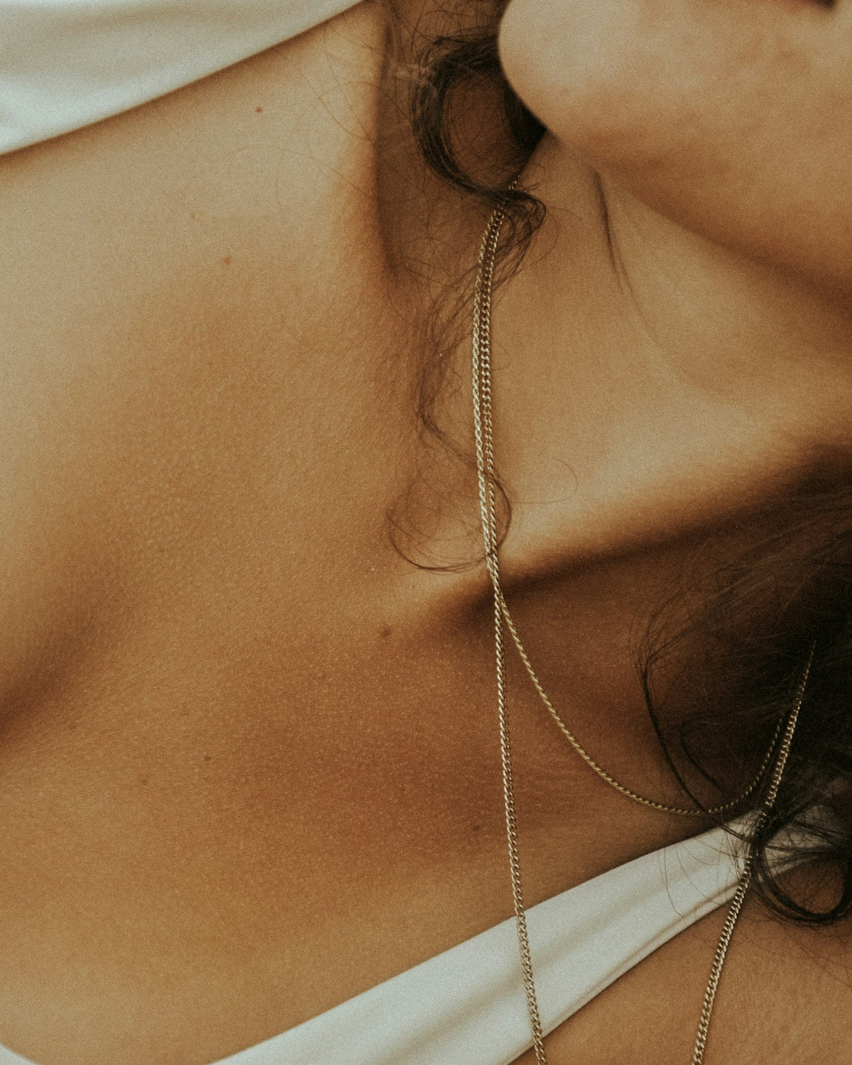 Fine chain draped at the collarbone