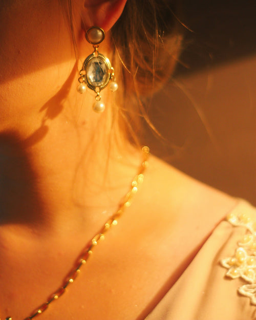 Earrings and necklace worn in warm light