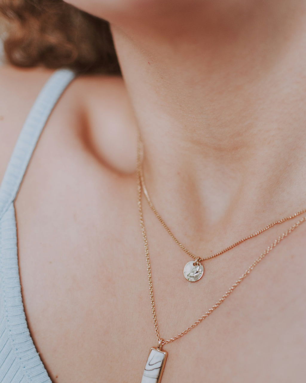 Halo drop pendant worn close to the collarbone