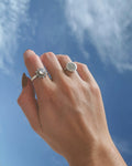 Silver rings worn against a blue sky