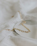 Paperclip chain necklace laid on white linen