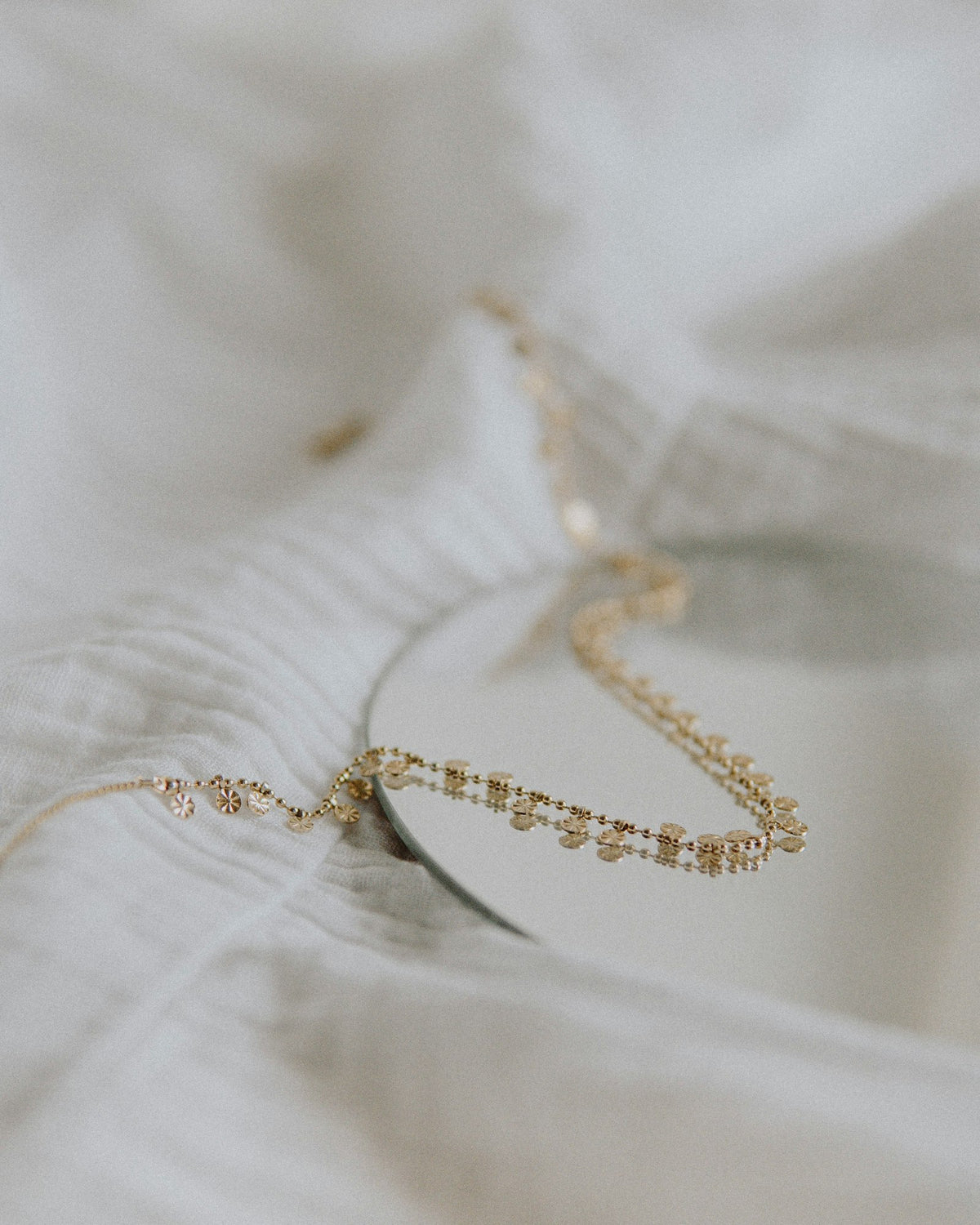 Paperclip chain necklace laid on white linen