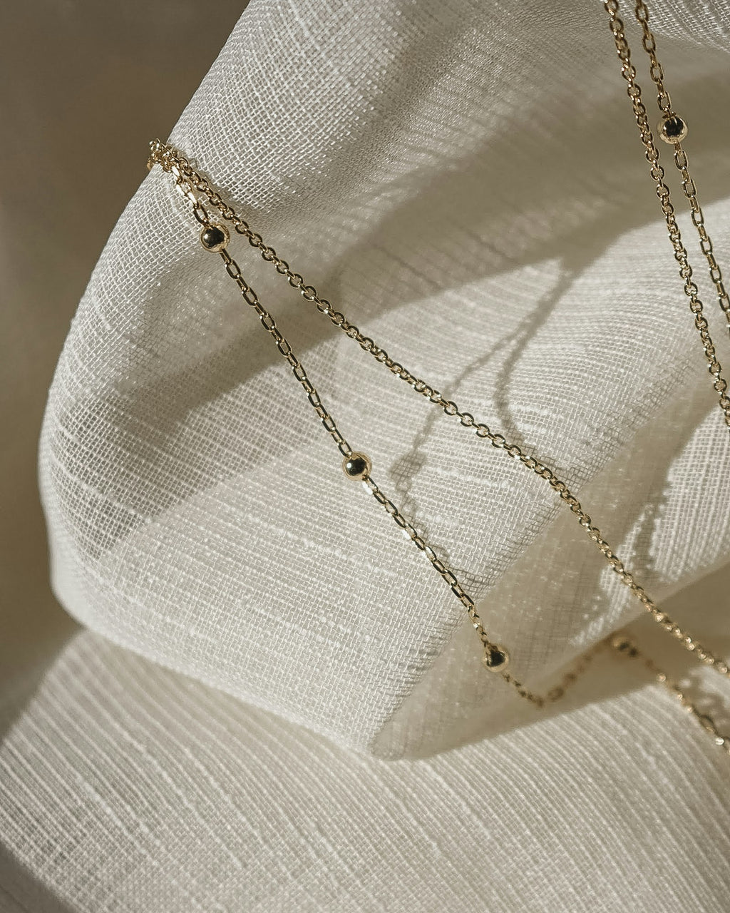 Fine body chain laid on linen