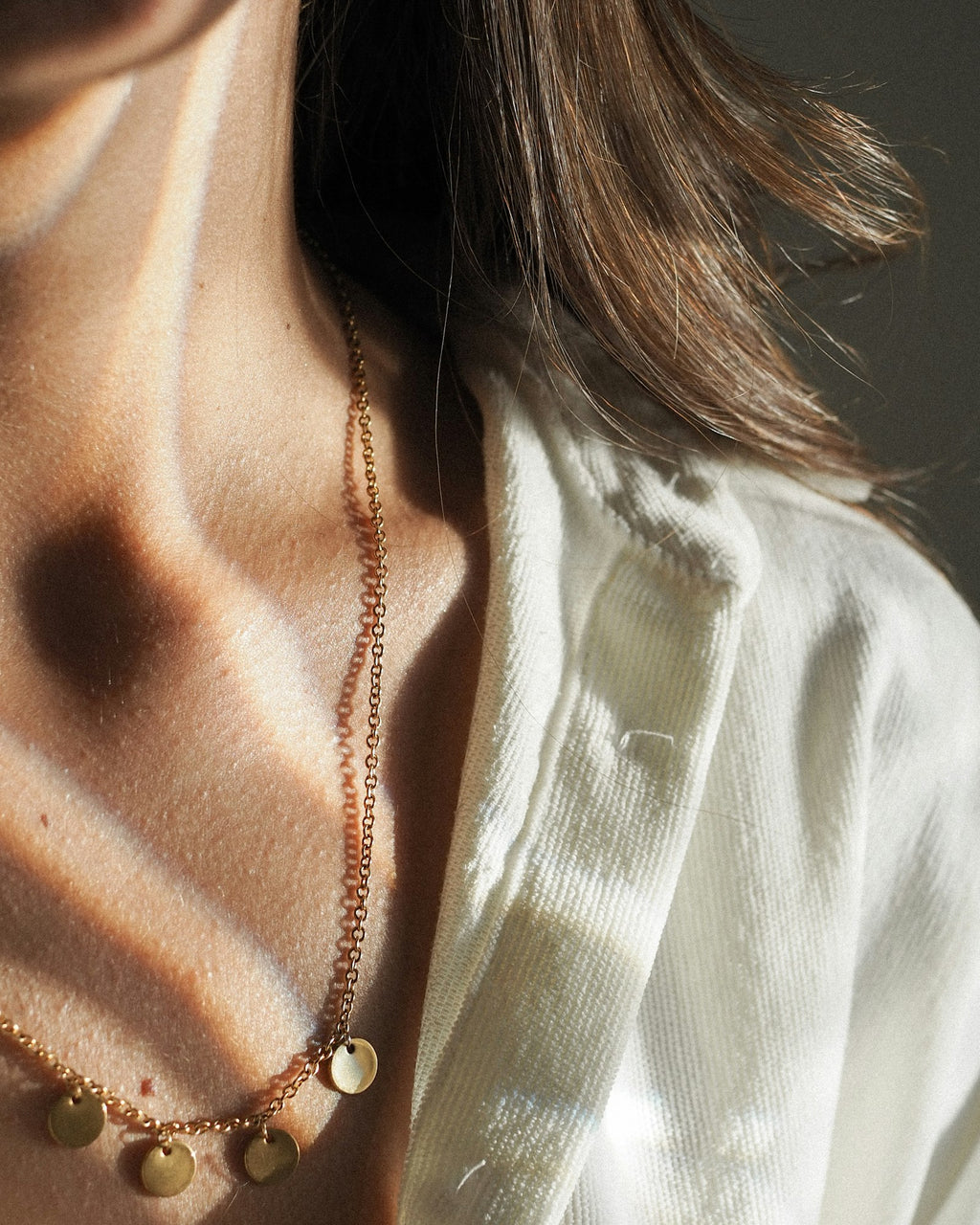 Layered necklaces worn close to the collarbone