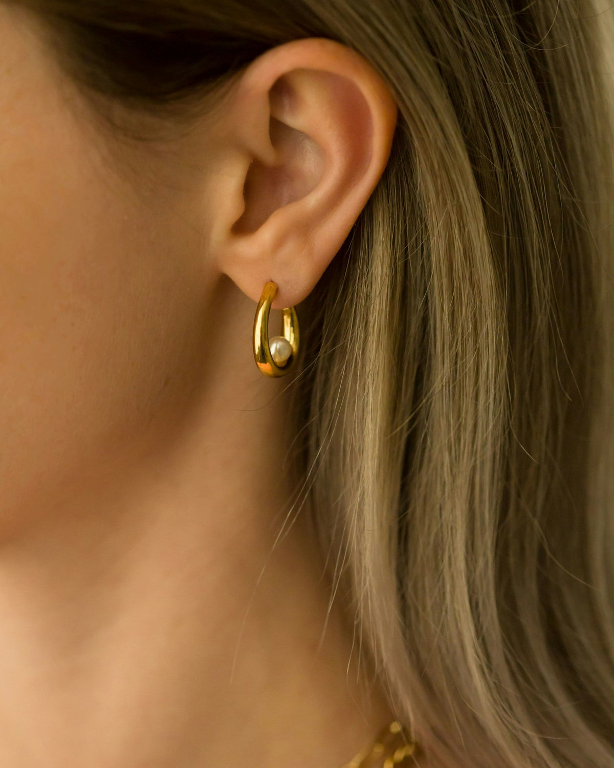 Hoop huggie earring worn on the ear