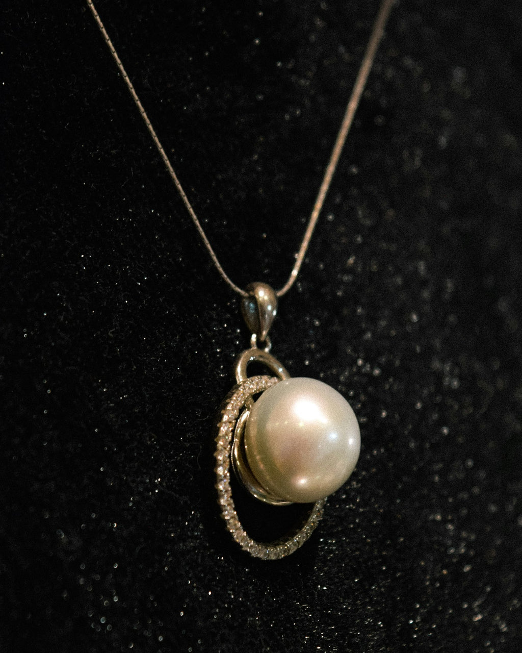 Pearl pendant on a black surface