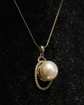 Pearl pendant on a black surface