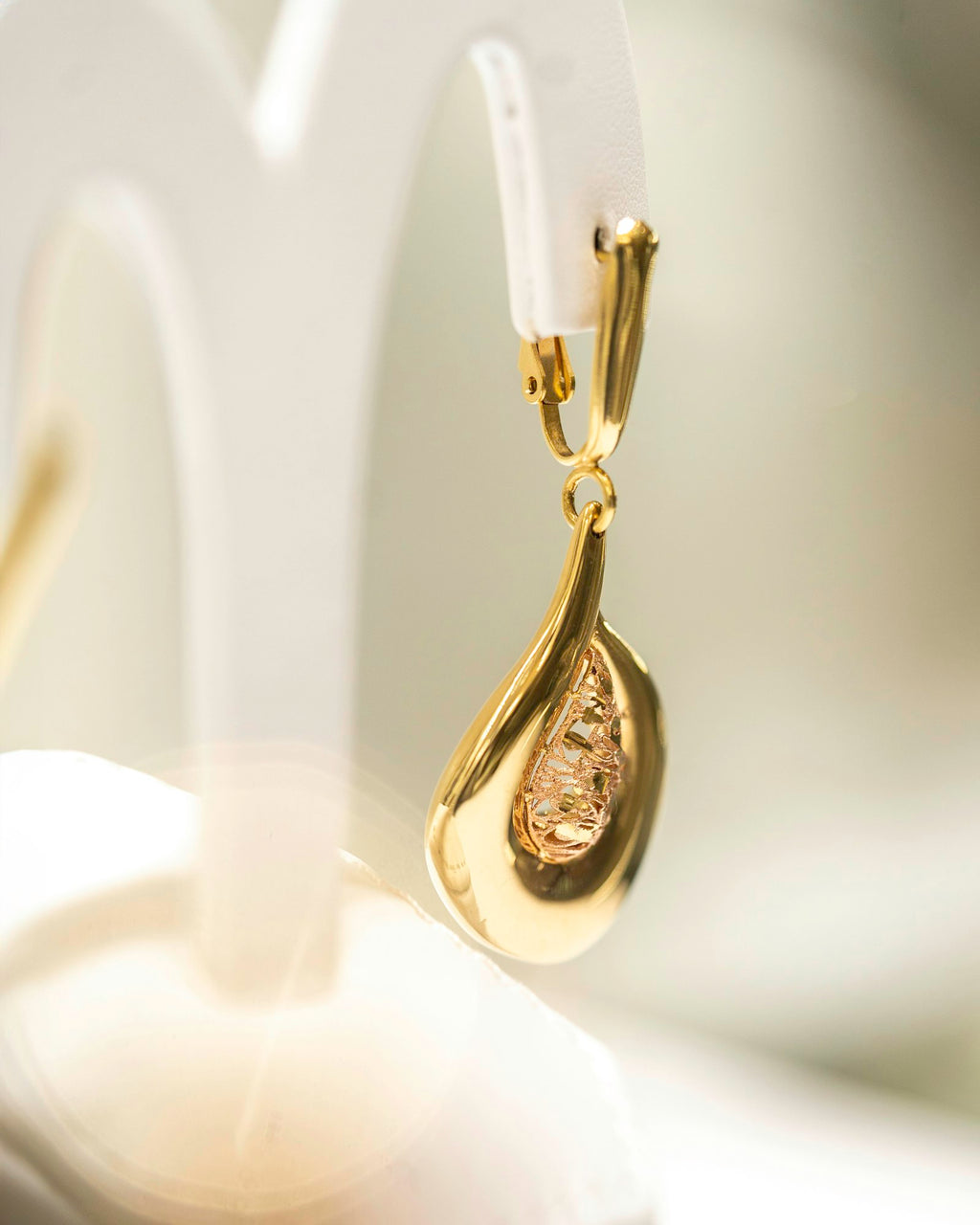 Drop earrings displayed on a stand