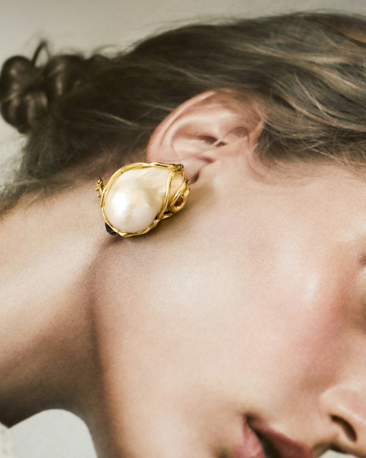 Pearl and gold earring worn on the ear