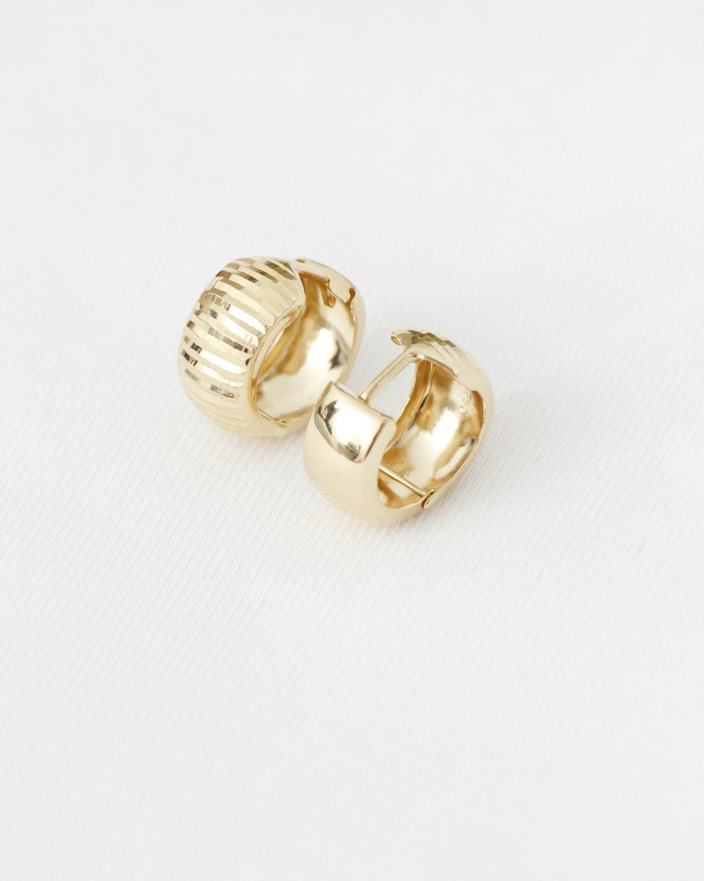Ribbed gold hoop earrings on white