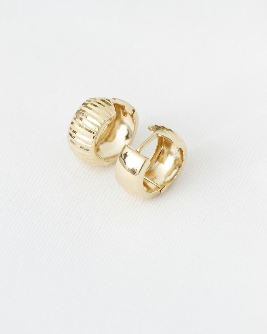 Ribbed gold hoop earrings on white