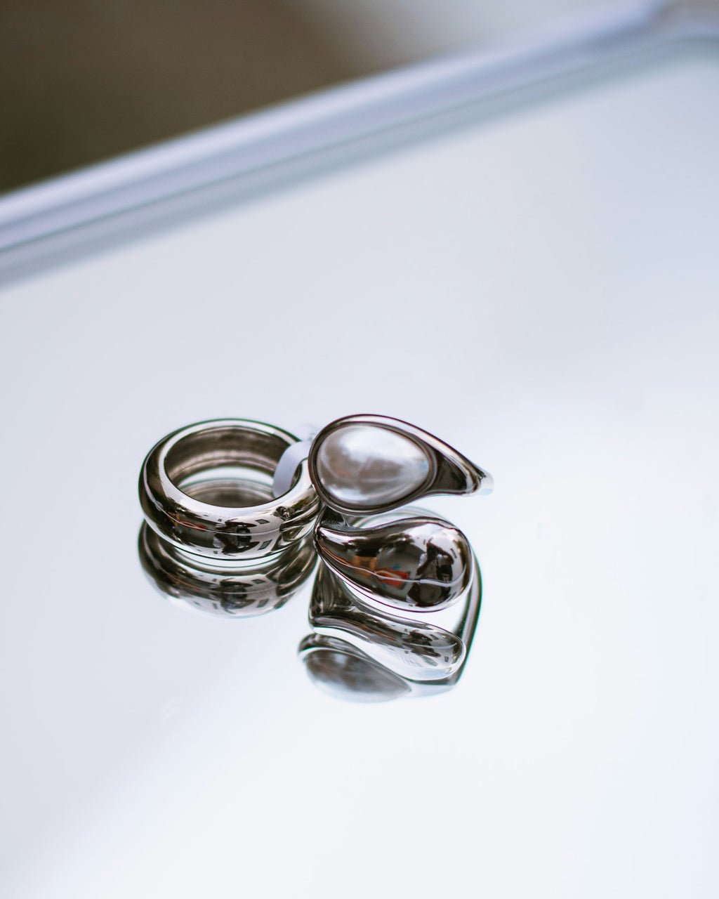 Polished silver dome rings on a reflective surface