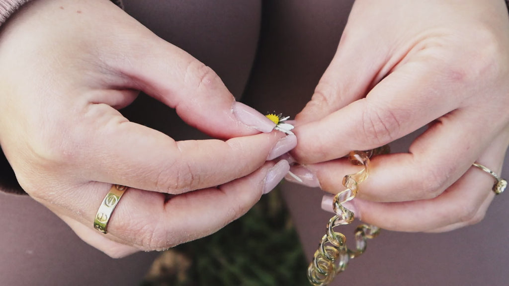 Hands wearing stacked rings, turning in soft light